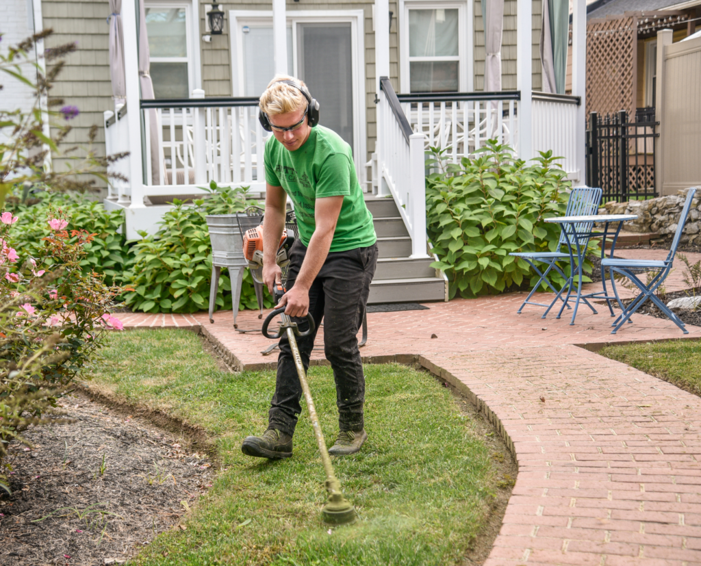 lawn care professional doing landscaping work on a home